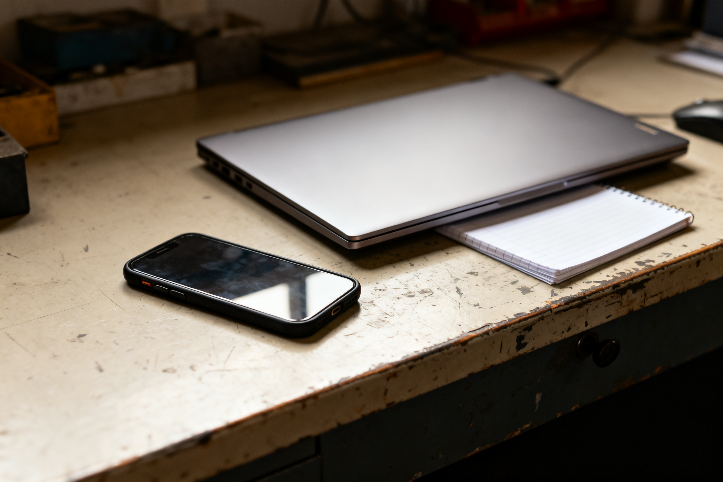 Smartphone beside a closed laptop on a worn desk — count calls before moving LSA budget